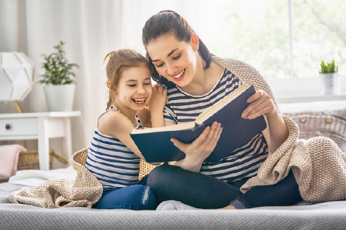 Mother and daughter read a book together.